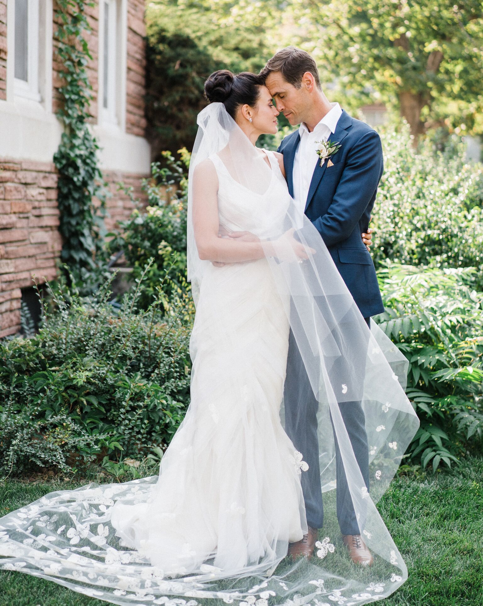 bride and groom outdoors with veil