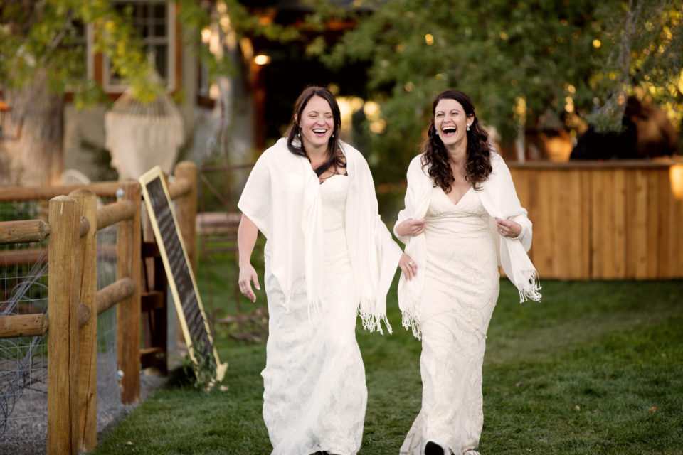 Brides white dresses white shawls laughing