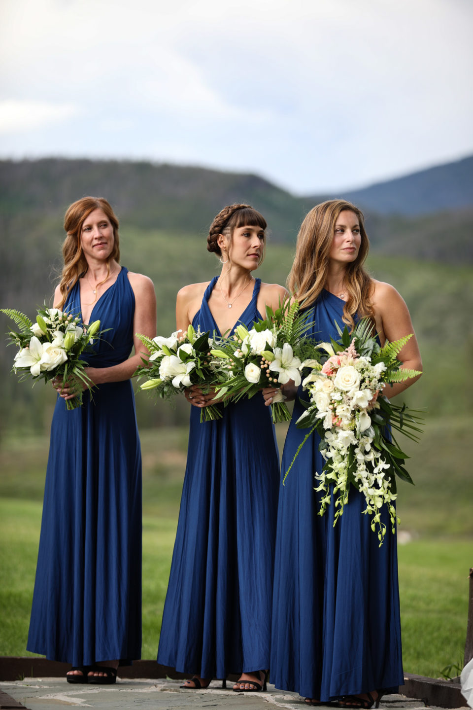 navy bridesmaids dresses white floral bouquets lilies ferns
